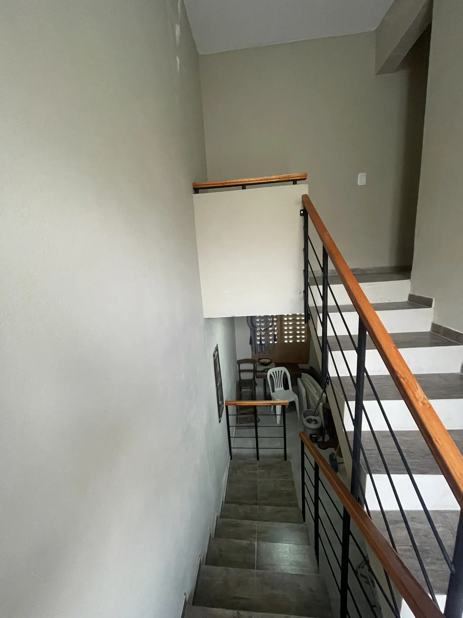 Vista general de la escalera con barandas metálicas y pasamanos de madera instalados