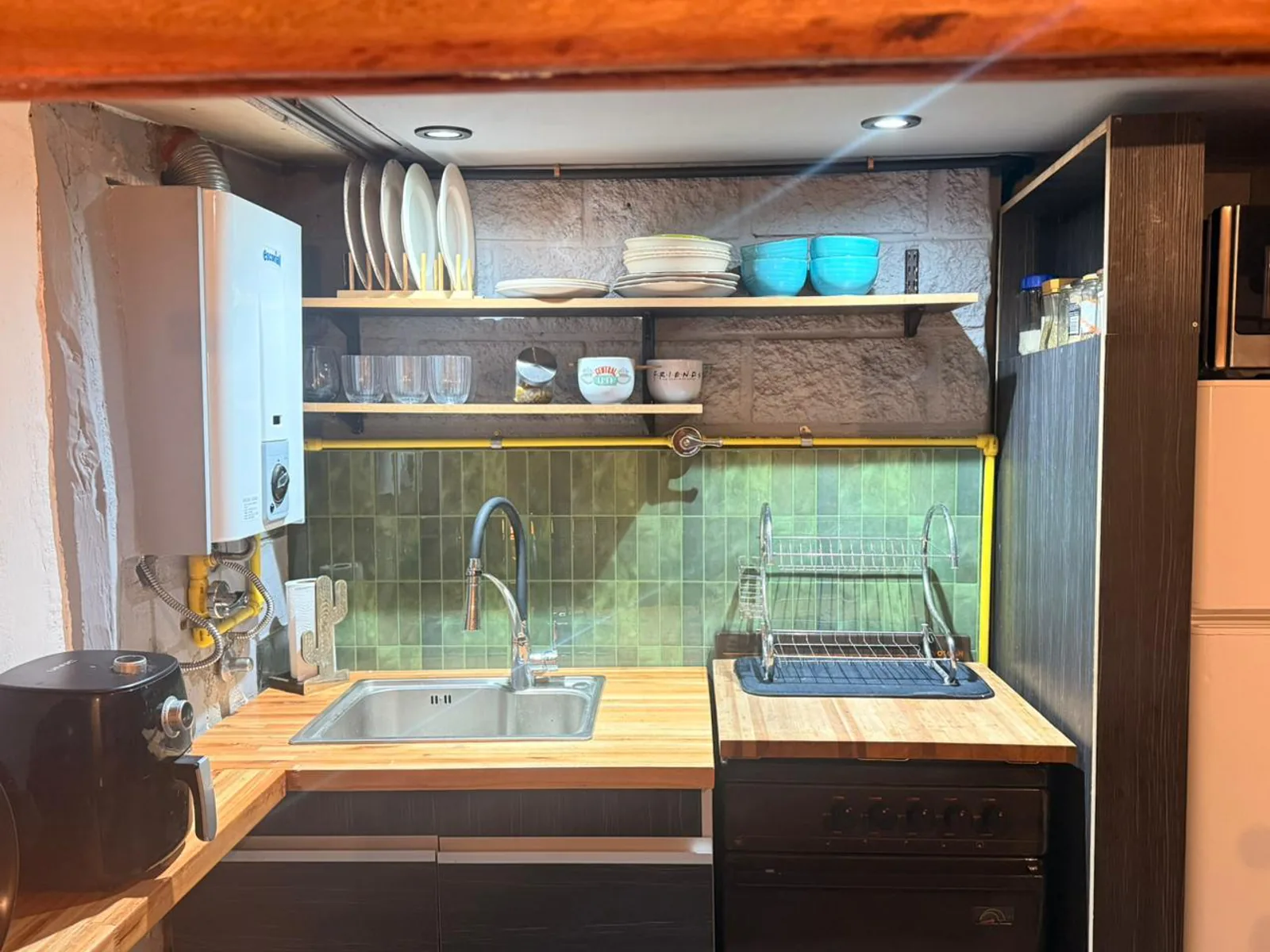 Cocina Carly terminada con mobiliario oscuro y mesadas de madera