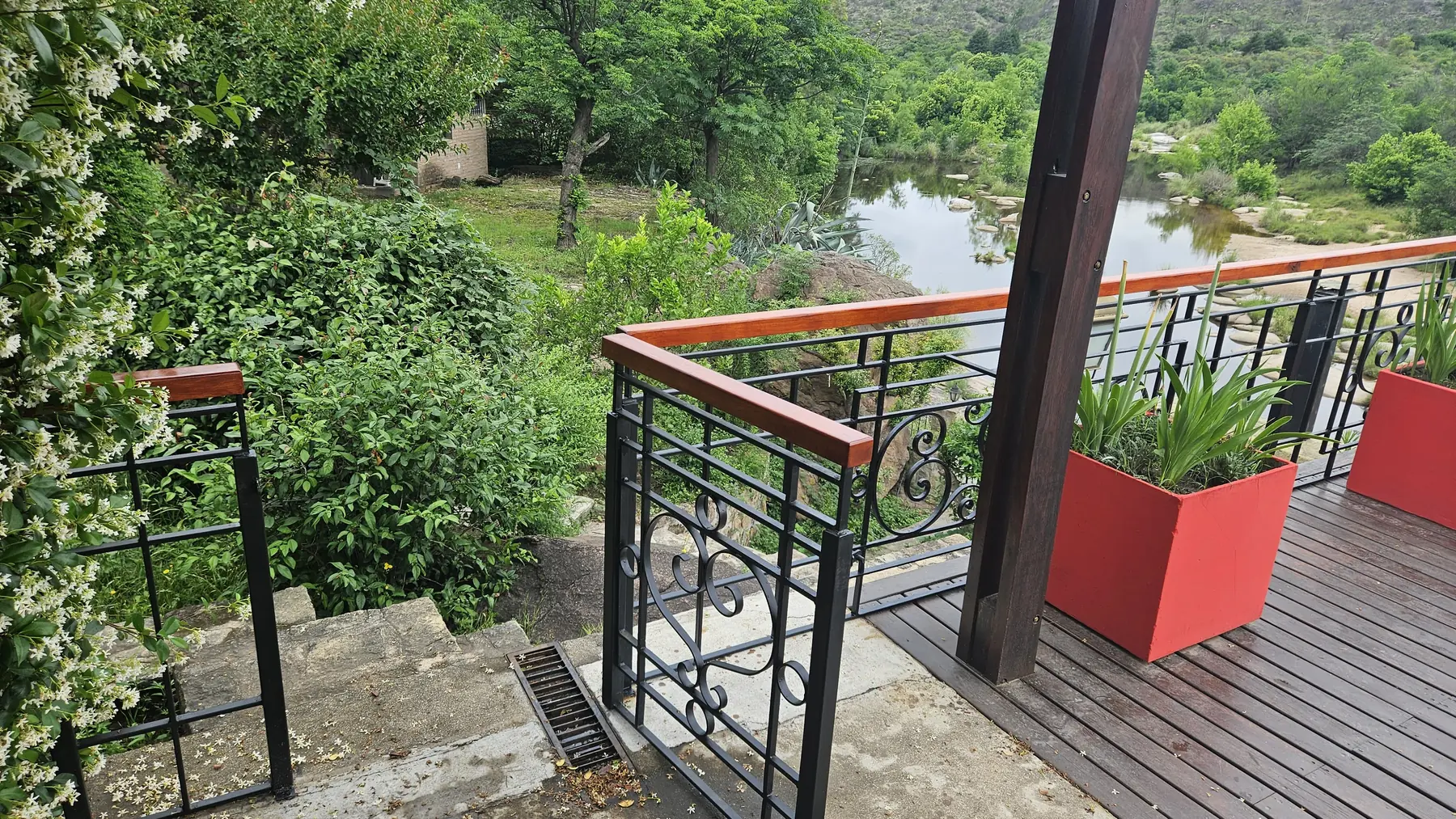 Pasamanos de madera instalados en barandas metálicas de un recorrido exterior